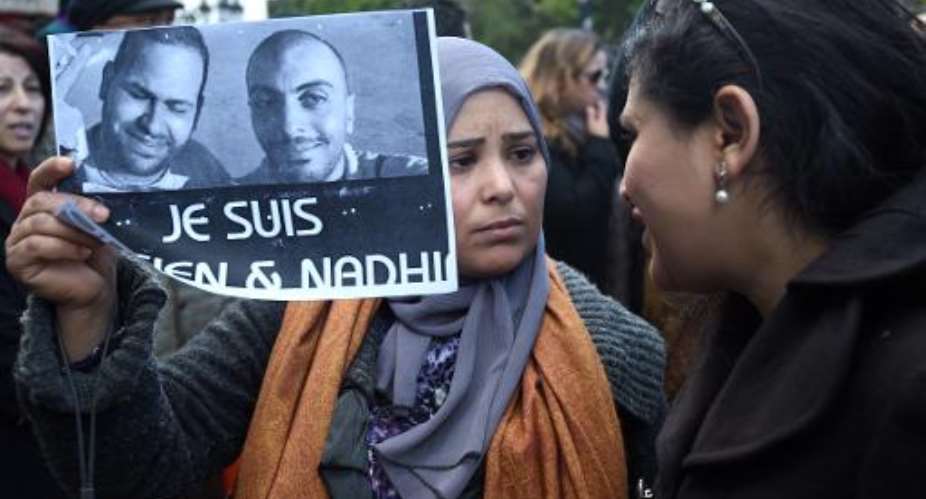 A Tunisian demonstrator holds a placard with the photo of Tunisian journalists Sofiene Chourabi and Nadhir Ktari which reads in French I am Sofiene and Nadhir during a demonstration in Tunis on January 9, 2015.  By Fethi Belaid AFPFile