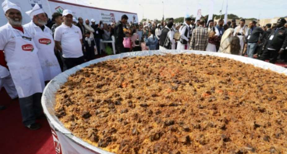 Libyan chefs and people gather around a giant couscous, on the site of the ancient Roman theatre of Sabratha, about 70 km west of the capital Tripoli.  By Mahmud Turkia AFP