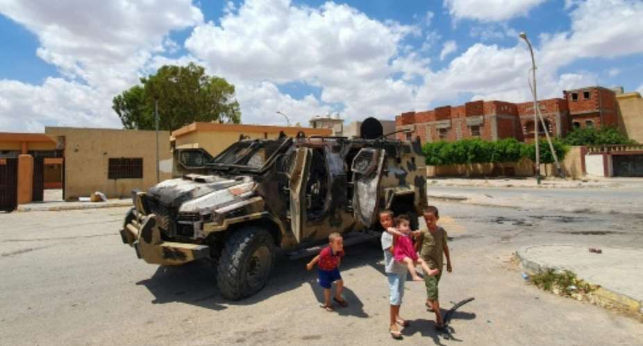 Libyan children play next to a burnt out vehicle belonging to forces loyal to strongman Khalifa Haftar in Gharyan, 100 kilometres 60 miles southwest of Tripoli, earlier this year; the UN has called for a humanitarian truce.  By Mahmud TURKIA AFPFile