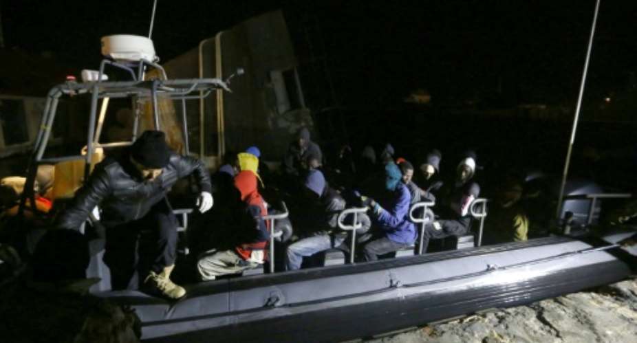 Libyan coastguards help migrants who were rescued at sea off the coast of Tripoli, on February 5, 2017.  By Mahmud Turkia AFP