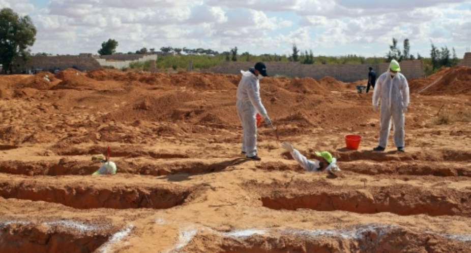 Libyan experts exhume human remains from mass graves in Tarhuna, southeast of the capital Tripoli, on Wednesday.  By Mahmud TURKIA AFP