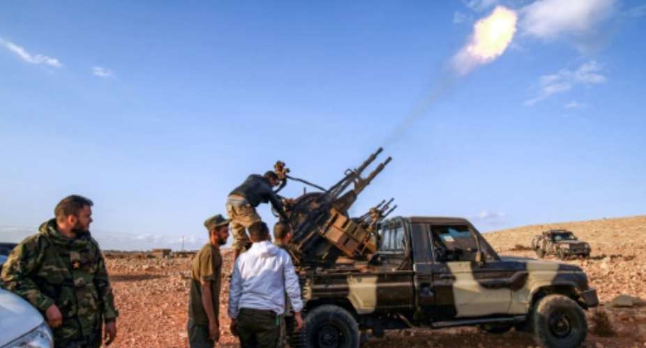 Libyan fighters loyal to eastern strongman Khalifa Haftar fire guns during a funeral of a comrade in November 1, 2020; Haftar has urged his troops 'drive out' Turkish forces.  By Abdullah DOMA AFP