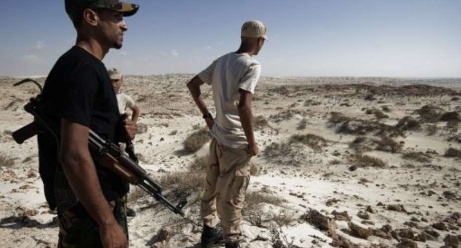 Libyan rebels stand on the oustskirts of the coastal oil town of Brega.  By Gianluigi Guercia (AFP/File)