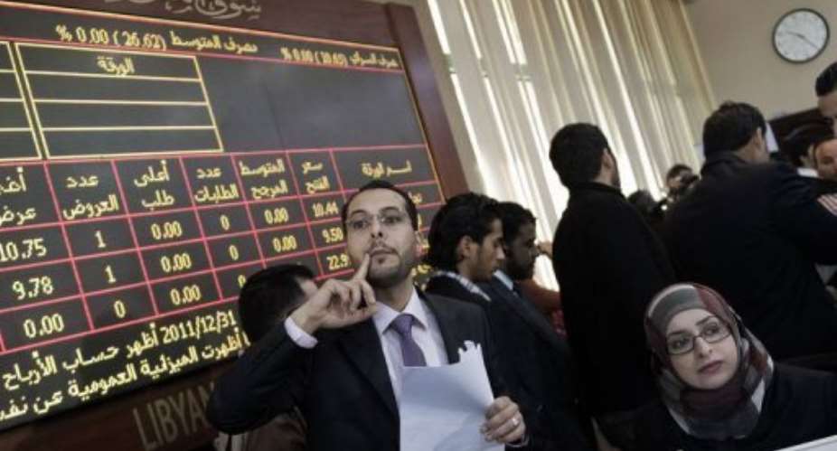 Brokers work during the official reopening of the Libyan stock market in Tripoli Thursday.  By Gianluigi Guercia AFP