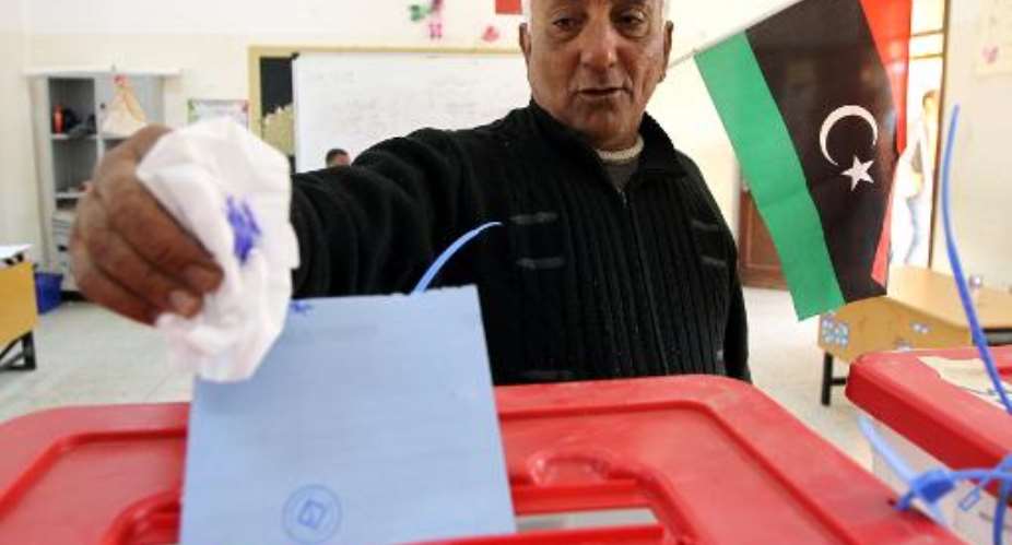 A Libyan man casts his vote to elect a constituent assembly at a polling station in the eastern city of Benghazi on February 20, 2014.  By Abdullah Doma AFP