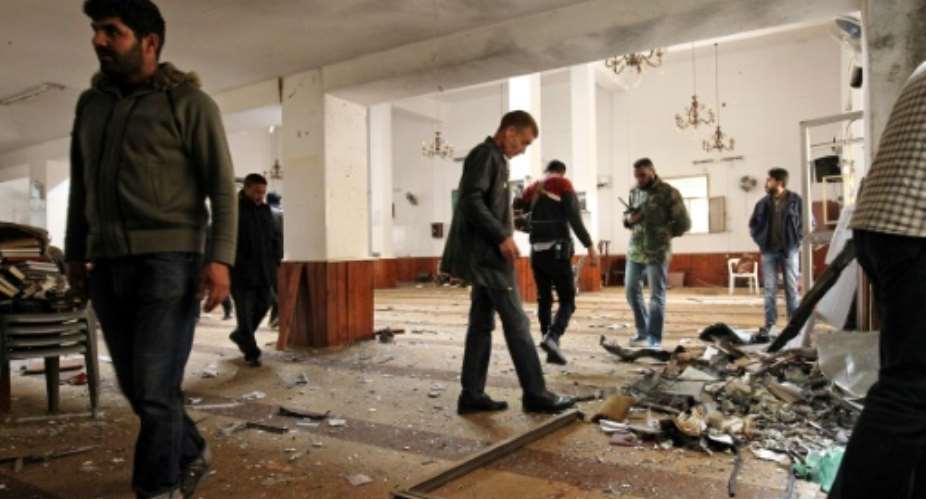 Libyans inspect the interior of a mosque in Benghazi on February 9, 2018, after it was hit by a twin bomb attack.  By Abdullah DOMA AFP
