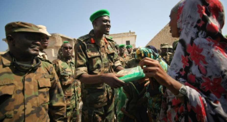 'Lion': Major General Paul Lokech, a brigadier at the time, handing out mosquito nets to civilians in Mogadishu in 2012.  By STUART PRICE AU-UN ISTAFPFile