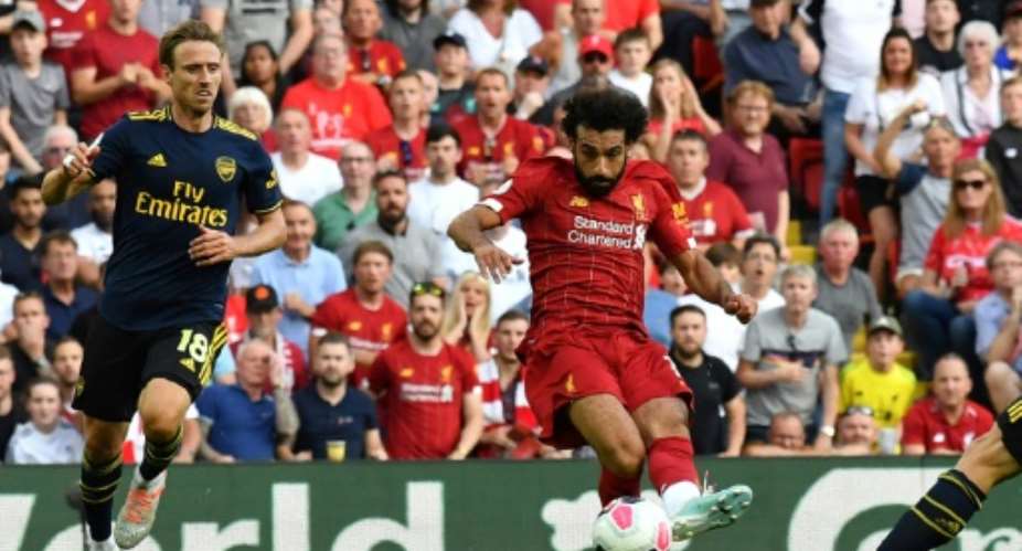 Liverpool's Egyptian midfielder Mohamed Salah C shoots to score his second goal, Liverpool's third during the English Premier League football match between Liverpool and Arsenal at Anfield in Liverpool, north west England on August 24, 2019..  By Ben STANSALL AFP