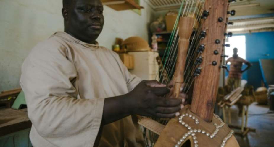 Long-necked kora harps are made with a calabash gourd as the soundbox.  By CARMEN ABD ALI AFP