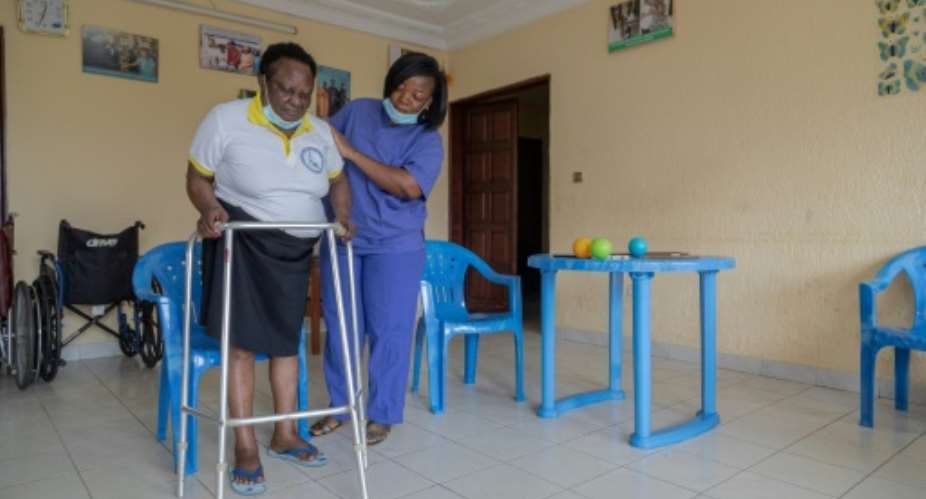 Lydie Ngapet, left, is one of eight people at the care home in Douala.  By Daniel Beloumou Olomo AFP