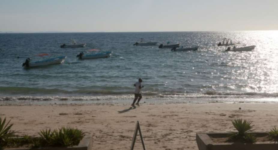A tourist runs on the beach of Ambatoloaka, Nosy Be, on October 9, 2013, where two Europeans were lynched by a mob.  By Rijasolo AFPFile