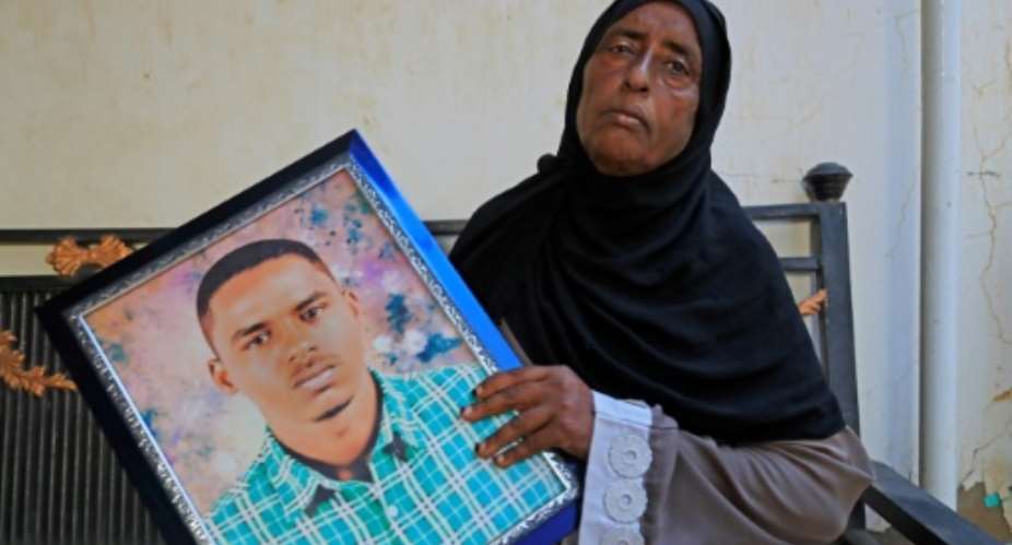 Mahasen Muhammad, 53, mother of slain Sudanese protester Gamal Shazly, holds his portrait during an interview at the family home in Khartoum.  By - (AFP)