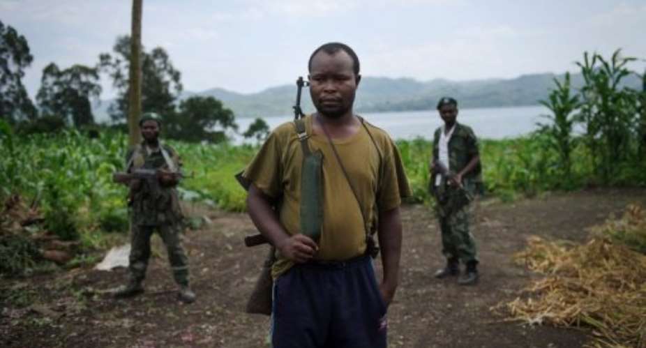 An APCLS Mai-Mai commander stands with his men near the village of Shasha on November 26, 2012.  By Phil Moore AFPFile