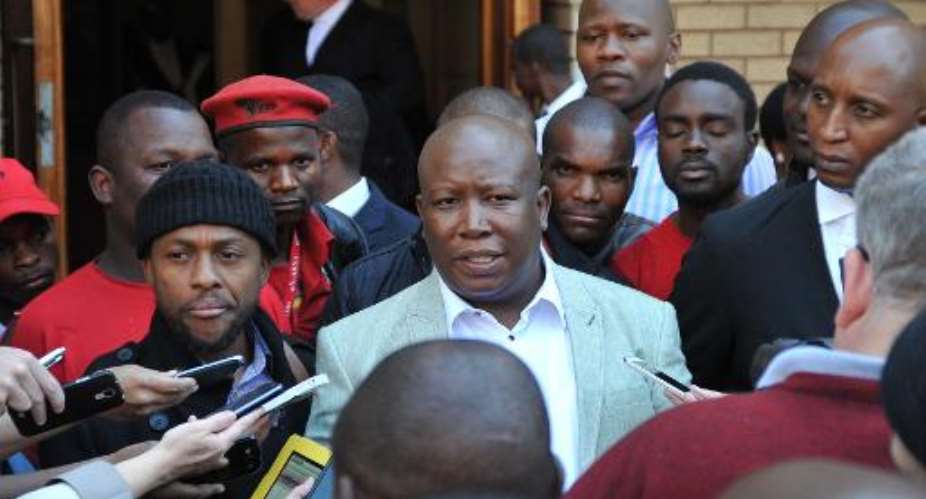 South African Economic Freedom Fighters party leader Julius Malema C addresses the media outside the North Gauteng High Court in Pretoria on August 25, 2014.  By Stefan Heunis AFPFile