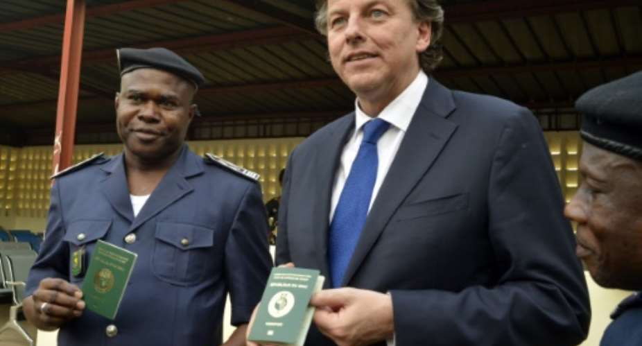 Dutch Foreign Minister Bert Koenders C and police officers pose with biometrical passeports at the Malian border police headquarters in Bamako on April 14, 2016.  By Habibou Kouyate AFPFile