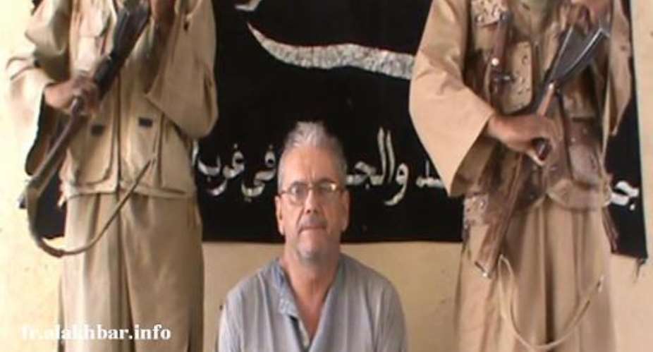 A pictre released on November 26, 2012 by Mauritanian news website Alakhbar, provided by the Islamist MUJAO group, shows French citizen Gilberto Rodrigues Leal under armed guard in an undisclosed place.  By  ALAKHBARAFPFile