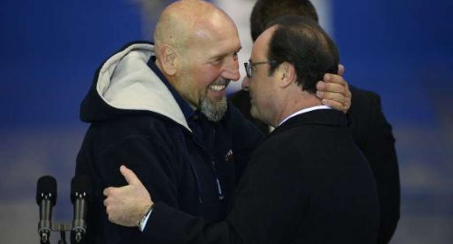 Former French hostage Serge Lazarevic L embraces President Francois Hollande after he landed at the Villacoublay military base near Paris on December 10, 2014.  By Bertrand Guay AFPFile