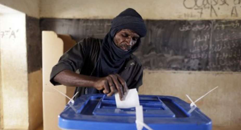 A man casts his ballots at a polling station on July 28, 2013 in Kidal, northern Mali.  By Kenzo Tribouillard AFPFile