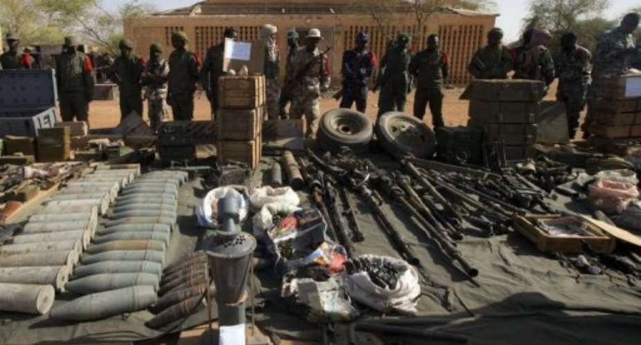 Soldiers stand in front of weapons and ammunition seized from Islamist fighters in Gao on February 24, 2013.  By Joel Saget AFPFile