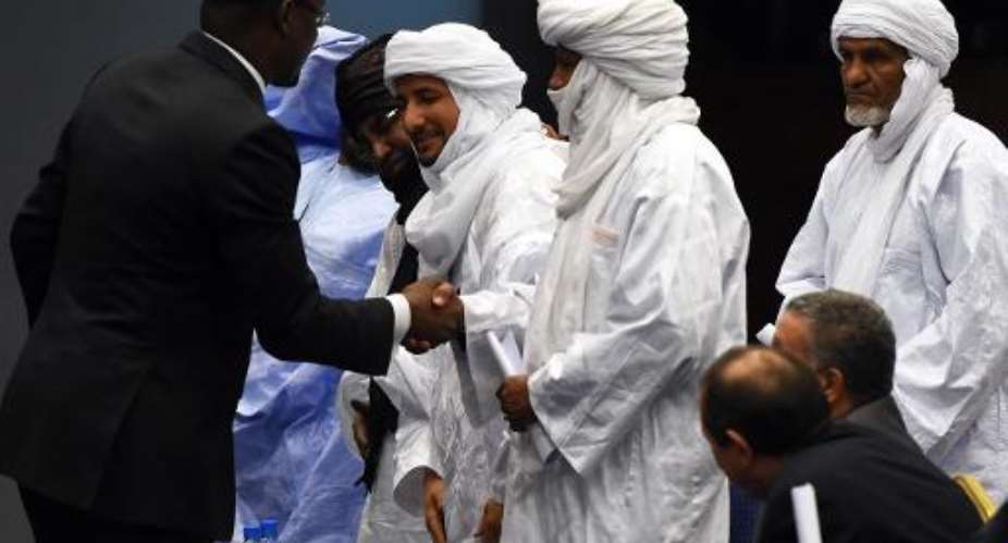 Malian Foreign Minister Abdoulaye Diop L shakes hands with representatives of Malian armed rebel groups at the end of a peace agreement ceremony on March 1, 2015 in the Algerian capital Algiers.  By Farouk Batiche AFPFile