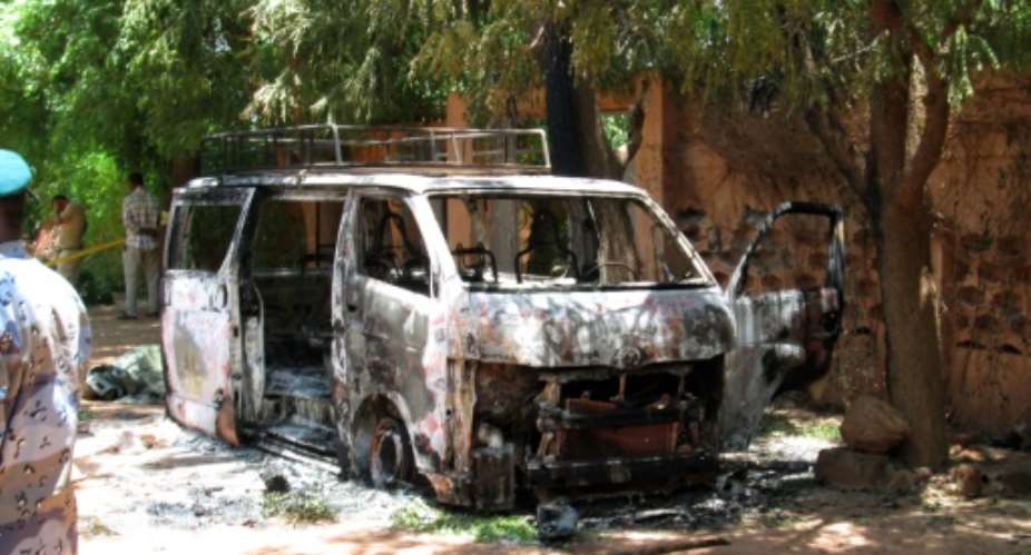 A burned vehicle in front of the Hotel Byblos in Sevare on August 8, 2015.  By - AFP