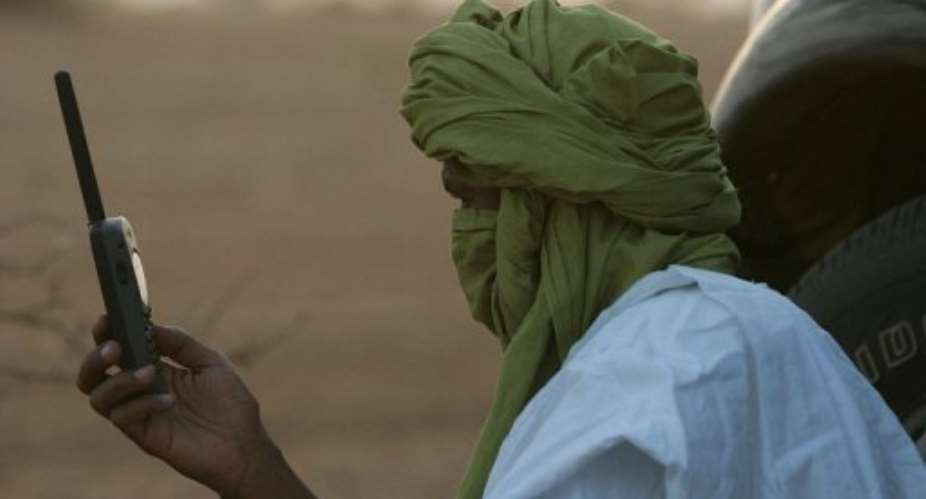 A Tuareg checks his satellite phone in the North Malian desert.  By Georges Gobet AFPFile