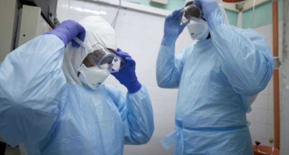Malian researchers get suited up to conduct a coronavirus test at a lab in Bamako.  By MICHELE CATTANI AFP