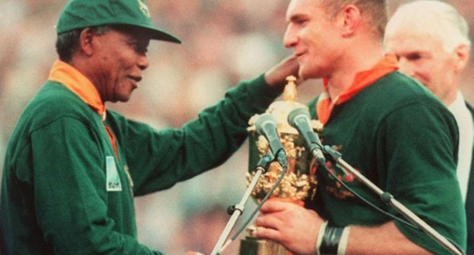South African President Nelson Mandela C congratulates Springbok skipper Francois Pienaar after handing him the William Webb Ellis trophy at Ellis Park in Johannesburg 24 June 1995.  By Jean-Pierre Muller AFPFile