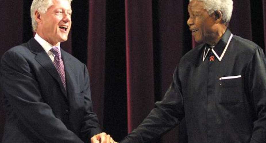 File photo taken on July 19, 2003 shows former US President Bill Clinton L shaking hands with former South African President Nelson Mandela at the Johannesburg Civic Centre.  By Rajesh Jantilal AFPFile