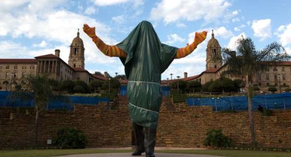 Still covered statue of South African former president Nelson Mandela is seen at the Union Buildings in Pretoria, on December 13, 2013.  By Irina Kalashnikova (AFP/File)