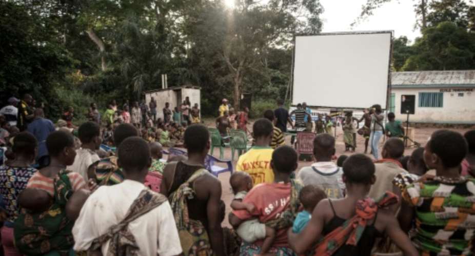 Many residents of a  village of the Mbyaka Pygmy people gather in Bayanga after a trek for the cinema night.  By FLORENT VERGNES AFP