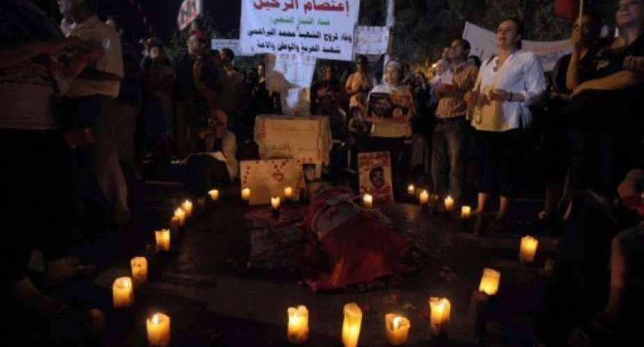 Tunisian protesters light candles by a symbolic coffin on August 4, 2013 in Tunis.  By Fethi Belaid AFPFile
