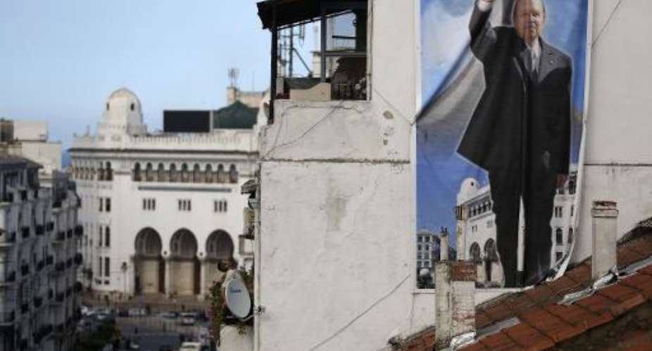 A poster showing Algerian President and candidate Abdelaziz Bouteflika hangs on a building in the center of the capital Algiers on April 17, 2014.  By Patrick Baz AFP
