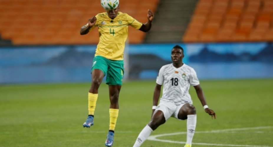 Match-winner Teboho Mokoena L of South Africa heads the ball watched by Marvelous Nakamba R of Zimbabwe during a World Cup qualifier in Johannesburg on Thursday..  By PHILL MAGAKOE AFP