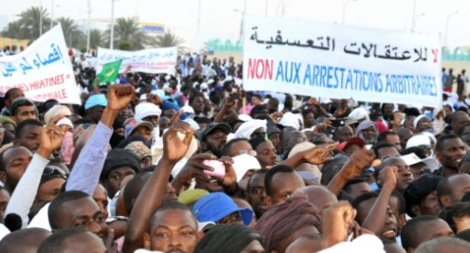 People hold a banner reading No to arbitrary arrests during a demonstration against discrimination in Nouakchott on April 29, 2015.  By  AFP