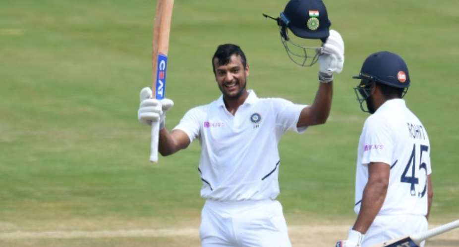 Mayank Agarwal raises his bat after reaching 100.  By NOAH SEELAM AFP
