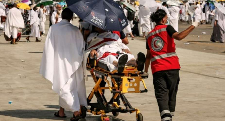 Medical team members evacuate a Muslim pilgrim, affected by the soarching heat, at the base of Mount Arafat, also known as Jabal al-Rahma or Mount of Mercy, during the annual hajj pilgrimage on June 15, 2024.  By Fadel SENNA (AFP/File)