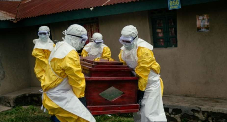 Members of a Congolese Red Cross team carry the coffin of a woman suspected of having died from Ebola in the eastern city of Bunia.  By Jospin Mwisha (AFP)