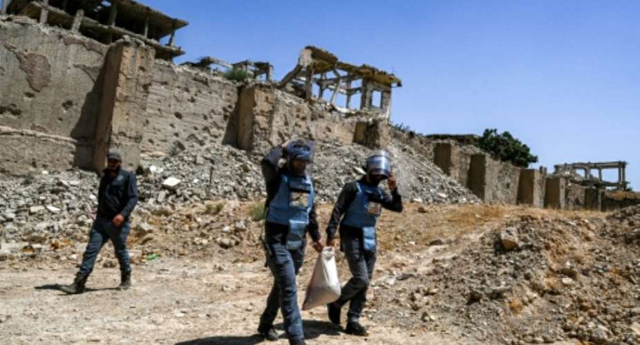 Members of a humanitarian NGO work to clear landmines and other explosive devices prepare to detonate unexploded war-remnants in a suburb of Damascus, Syria.  By LOUAI BESHARA (AFP)