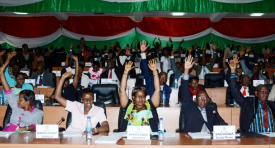 Members of Burundi's National Assembly raise their arm to vote on October 12, 2016 in Bujumbura, for the withdrawal of the International Criminal Court (ICC) from the capital.  By Onesphore Nibigira (AFP/File)