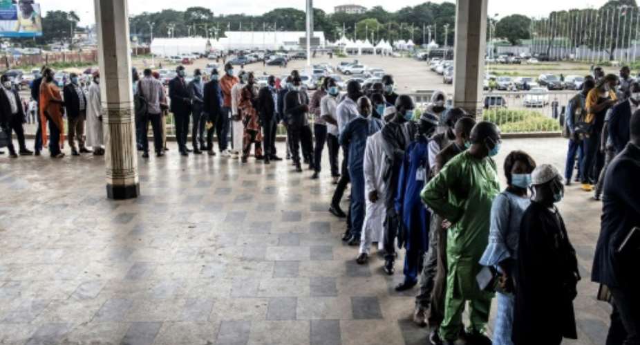 Members of Guinea's civil society wait in line at the Peoples Palace ahead of talks with Colonel Mamady Doumbouya.  By JOHN WESSELS AFP