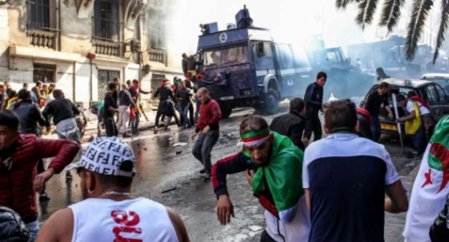 Members of the Algerian riot police clash with protesters as they try to disperse them during an anti-government demonstration in the capital Algiers.  By - AFP