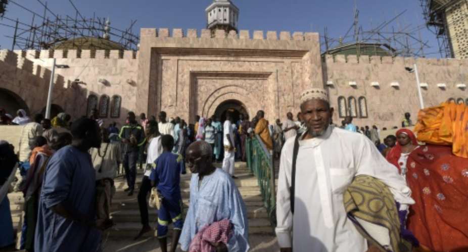 Members of the Mouride Brotherhood, a large Sufi order largely present in Senegal, queue to enter the Great Mosque in Touba on November 19, 2016.  By Seyllou AFP
