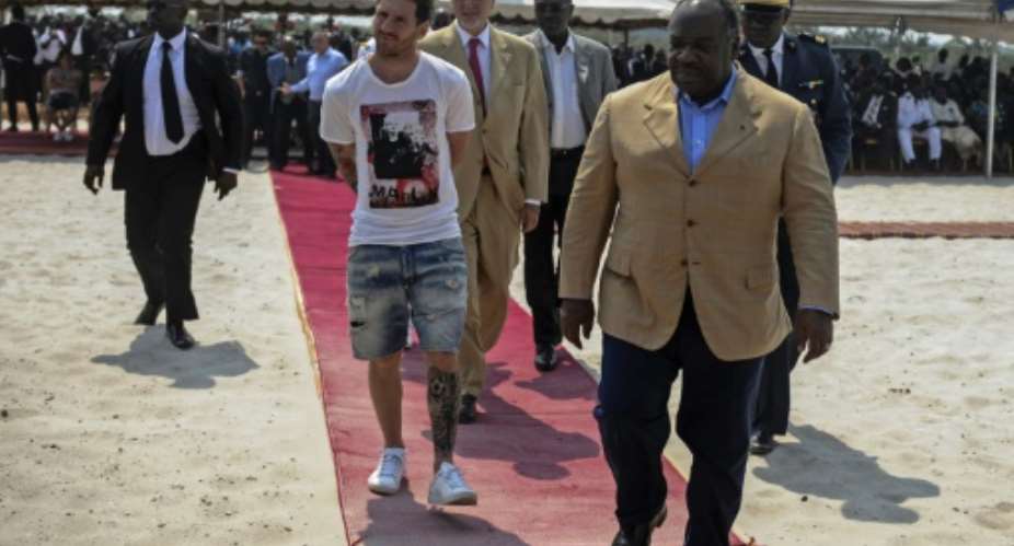 FIFA Ballon d'Or winner Lionel Messi C is given a tour during the start of construction of the Port-Gentil Stadium by the President of Gabon, Ali Bongo Ondimba R in the Ntchengue district of Port-Gentil on July 18, 2015.  By Steve Jordan AFPFile