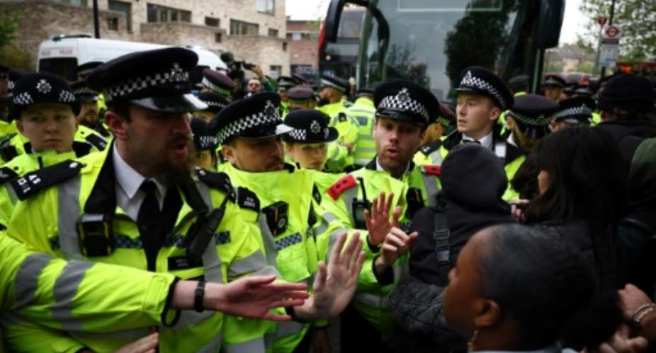 Metropolitan Police officers clash with protesters taking part in a gathering around a bus reportedly waiting to remove migrants and asylum seekers from a hotel in Peckham, south London.  By HENRY NICHOLLS AFP
