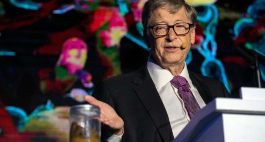 Microsoft founder Bill Gates talks next to a container with human feces, a stunt to draw attention to the lack of toilets in developing countries around the world.  By Nicolas ASFOURI AFP