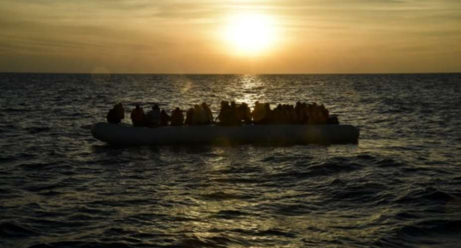 Migrants and refugees sit on a rubber boat before to be rescued by the ship Topaz Responder run by Maltese NGO Moas and Italian Red Cross off the Libyan coast in the Mediterranean Sea, on November 5, 2016 off the coast of Libya.  By ANDREAS SOLARO AFPFile