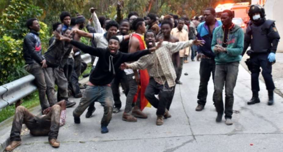 Migrants celebrate outside the Center for Temporary Stay of Immigrants CETI after forcing their way through fence between Morocco and Spanish enclave of Ceuta, on February 17, 2017.  By Antonio Sempere AFPFile