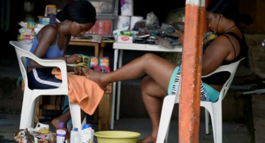 Migrants from Haiti and African countries stuck in the Mexican town of Tapachula do menial work to get by, such as giving pedicures.  By ALFREDO ESTRELLA AFPFile