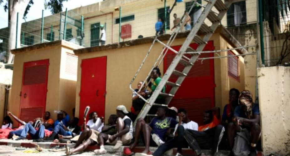 Migrants sit outside the CETI short-stay migrant centre in the Spanish North African enclave of Ceuta.  By Henry Nicholls (AFP/File)